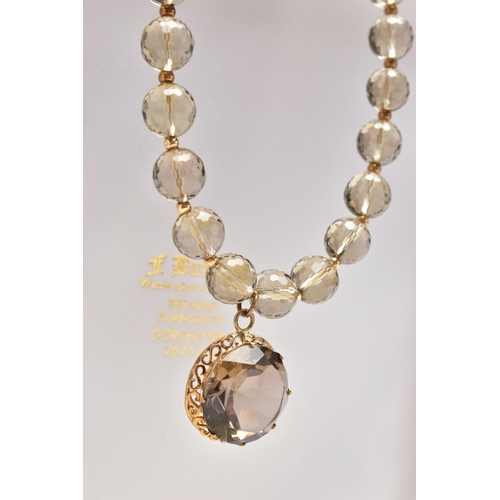 26 - A SMOKY QUARTZ BEADED NECKLACE AND MATCHING EARRINGS, the necklace made up of thirty-eight faceted r... 