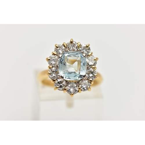 4 - A YELLOW METAL AQUAMARINE AND DIAMOND CLUSTER RING, centring on a four claw set, cushion cut aquamar... 