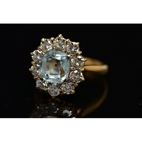 4 - A YELLOW METAL AQUAMARINE AND DIAMOND CLUSTER RING, centring on a four claw set, cushion cut aquamar... 