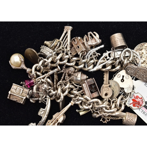 45 - A SILVER CHARM BRACELET, curb link chain, hallmarked Birmingham, fitted with twenty-eight charms in ... 