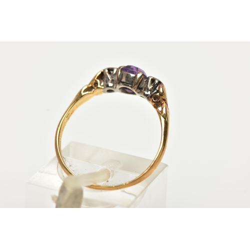 48 - A YELLOW METAL AMETHYST AND DIAMOND RING, centring on a claw set, circular cut amethyst, flanked wit... 