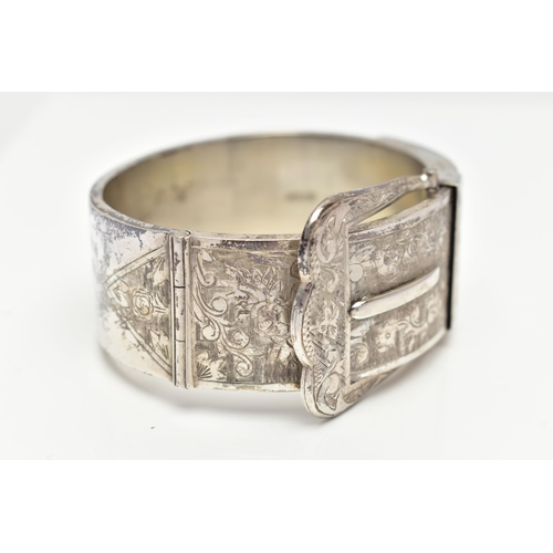 6 - A SILVER HINGED BANGLE, in the form of a belt and buckle, decorated with a floral pattern, hallmarke... 