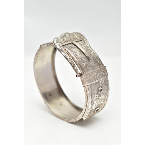 6 - A SILVER HINGED BANGLE, in the form of a belt and buckle, decorated with a floral pattern, hallmarke... 