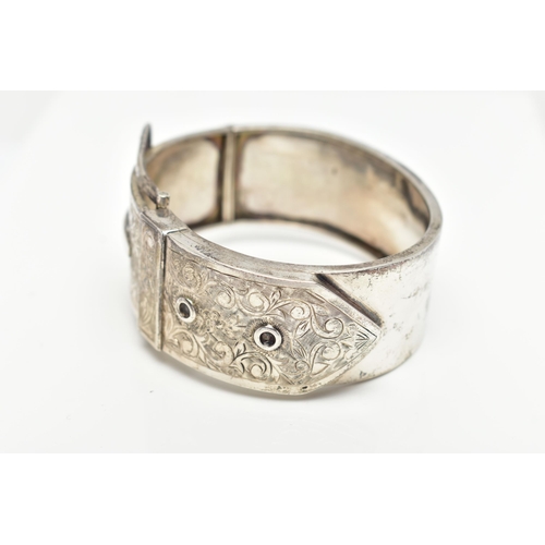 7 - A SILVER HINGED BANGLE, in the form of belt and buckle, decorated with a floral pattern, hallmarked ... 