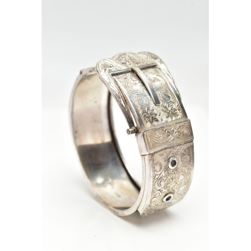 7 - A SILVER HINGED BANGLE, in the form of belt and buckle, decorated with a floral pattern, hallmarked ... 