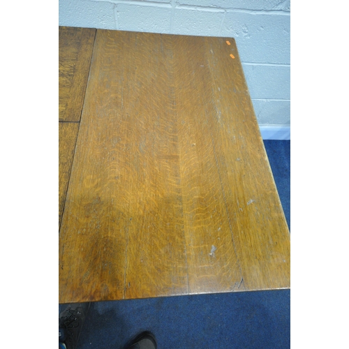 1218 - A 20TH CENTURY SOLID OAK DRAW LEAF TABLE, with a single fold out leaf, on block and acorn legs, unit... 