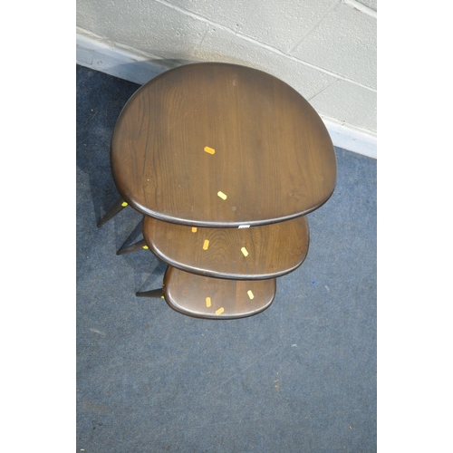 1228 - A DARK ERCOL ELM AND BEECH NEST OF THREE PEBBLE TALBES, largest table width 66cm x depth 44cm x heig... 