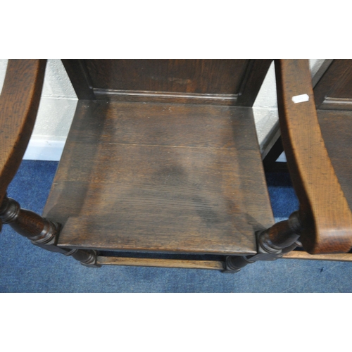 1241 - A SET OF FOUR LATE 20TH CENTURY OAK CHAIRS, including one carver, with panelled backs, on block and ... 