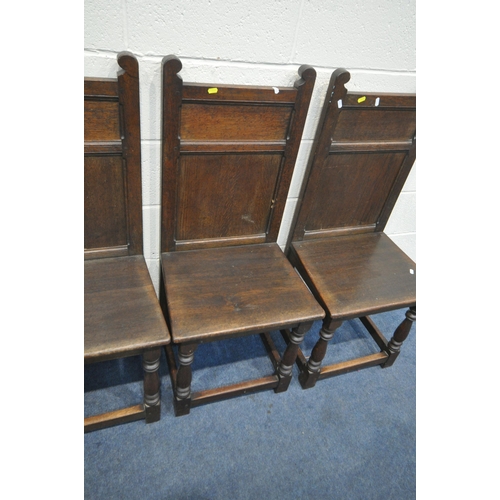 1241 - A SET OF FOUR LATE 20TH CENTURY OAK CHAIRS, including one carver, with panelled backs, on block and ... 