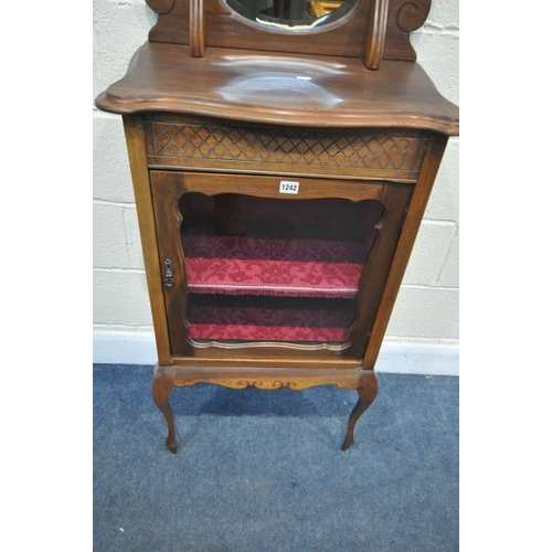 1242 - AN EDWARDIAN MAHOGANY MUSIC CABINET, with a raised mirrored back, above a single glazed door, on fro... 