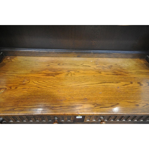 1255 - A 20TH CENTURY OAK DRESSER, the top with two lead glazed doors, base with two drawers over two cupbo... 