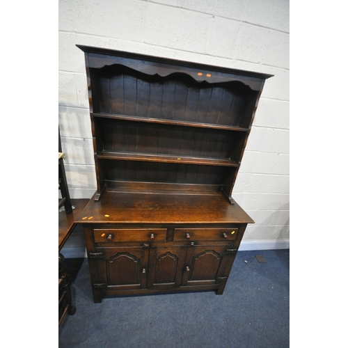 1257 - A 20TH CENTURY OAK DINING SUITE, comprising a draw leaf dining table, on twin acorn supports, extend... 