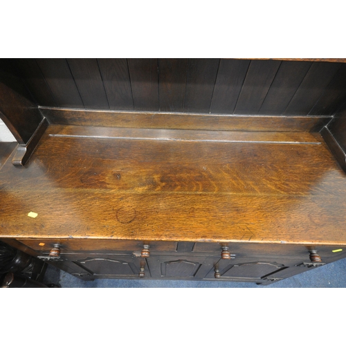 1257 - A 20TH CENTURY OAK DINING SUITE, comprising a draw leaf dining table, on twin acorn supports, extend... 