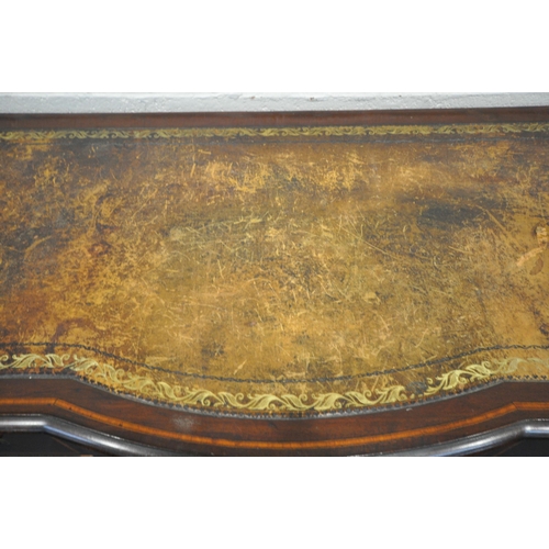 1277 - AN EDWARDIAN MAHOGANY AND INLAID BOW FRONT DESK, with a distressed leather writing surface, five dra... 