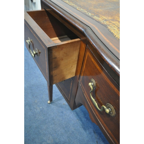 1277 - AN EDWARDIAN MAHOGANY AND INLAID BOW FRONT DESK, with a distressed leather writing surface, five dra... 