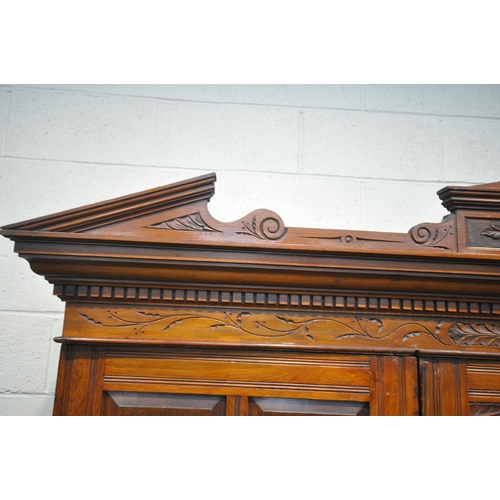 1280 - AN EDWARDIAN WALNUT TRIPLE DOOR COMPACTUM WARDROBE, with an overhanging cornice with foliate carving... 