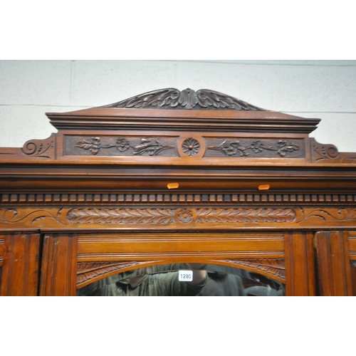 1280 - AN EDWARDIAN WALNUT TRIPLE DOOR COMPACTUM WARDROBE, with an overhanging cornice with foliate carving... 