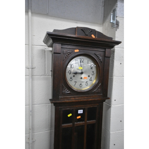 1283 - AN EARLY 20TH CENTURY OAK CHIMING LONGCASE CLOCK, with a brass and silvered dial, on a glazed trunk,... 