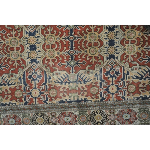 1307 - A TURKISH TABRIZ RUG, with a repeating geometric design, red field, an multi strap border, 235cm x 1... 