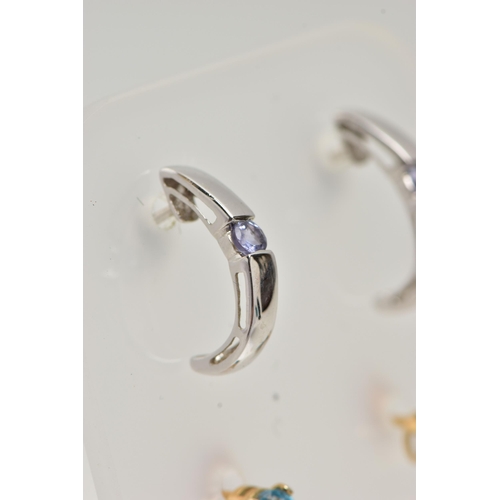 12 - TWO PAIRS OF GEM SET EARRINGS, the first a pair of curved drop earrings each set with a circular cut... 