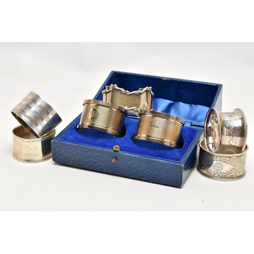 155 - A PAIR OF CASED GEORGE V SILVER CIRCULAR NAPKIN RINGS AND FIVE OTHER SILVER NAPKIN RINGS, the cased ... 