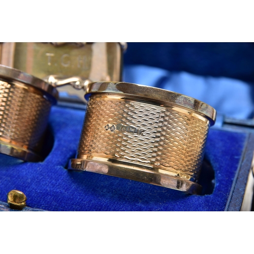 155 - A PAIR OF CASED GEORGE V SILVER CIRCULAR NAPKIN RINGS AND FIVE OTHER SILVER NAPKIN RINGS, the cased ... 