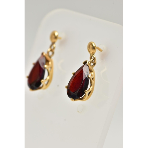 17 - A PAIR OF GARNET DROP EARRINGS, each set with a pear cut garnet drop, claw set into a yellow gold mo... 