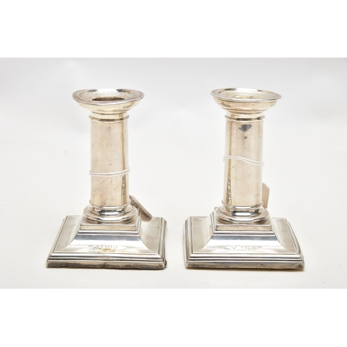 174 - A PAIR OF LATE VICTORIAN SILVER CANDLESTICKS, polished columns, on weighted square bases, engraved i... 