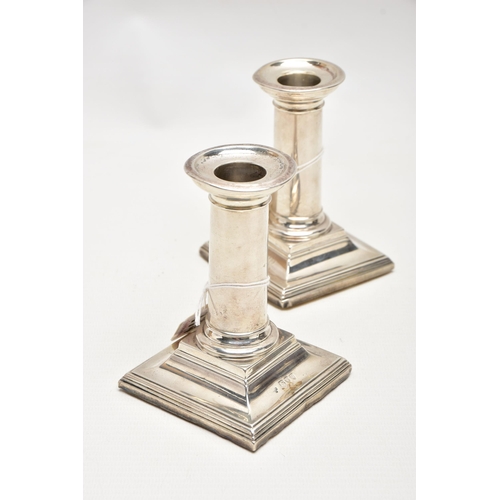 174 - A PAIR OF LATE VICTORIAN SILVER CANDLESTICKS, polished columns, on weighted square bases, engraved i... 