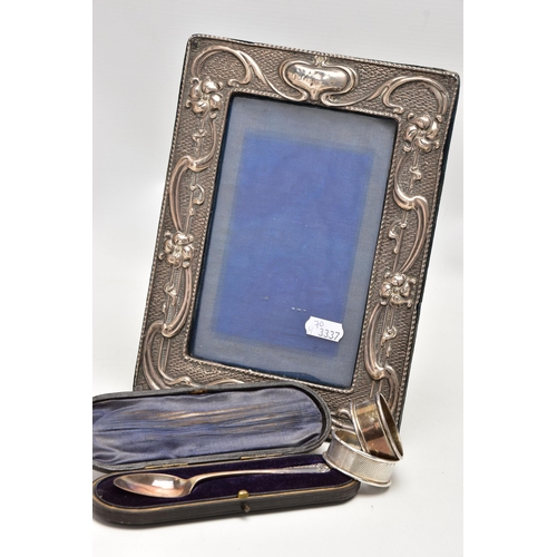 186 - AN EDWARDIAN SILVER PHOTO FRAME, TWO NAPKIN RINGS AND A CASED TEASPOON, the rectangular photo frame ... 