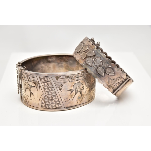 37 - TWO LATE VICTORIAN SILVER BANGLES, the first a wide hinged bangle, decorated with engraved birds and... 