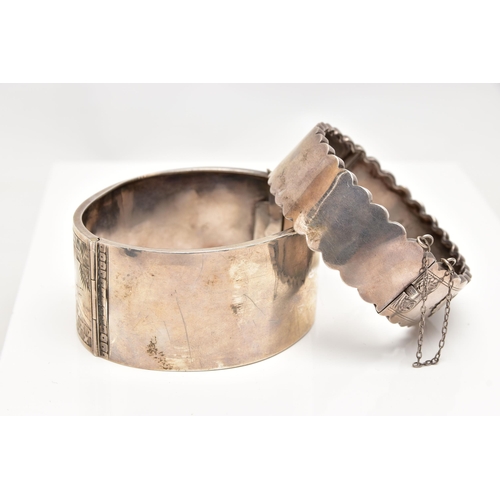 37 - TWO LATE VICTORIAN SILVER BANGLES, the first a wide hinged bangle, decorated with engraved birds and... 