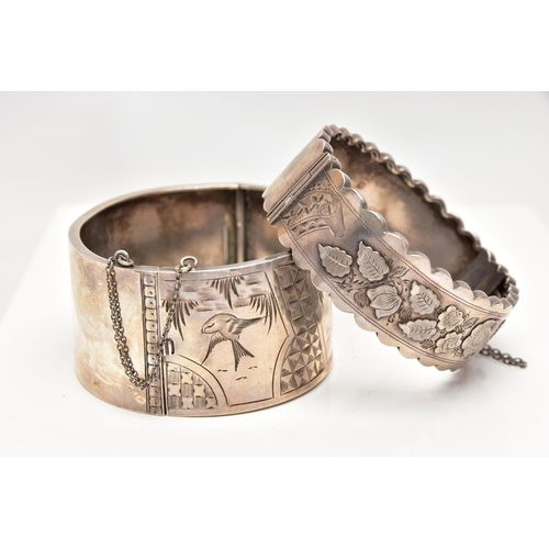 37 - TWO LATE VICTORIAN SILVER BANGLES, the first a wide hinged bangle, decorated with engraved birds and... 