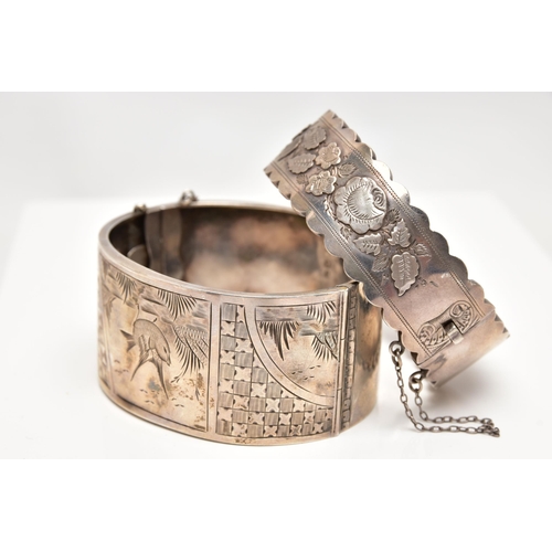 37 - TWO LATE VICTORIAN SILVER BANGLES, the first a wide hinged bangle, decorated with engraved birds and... 