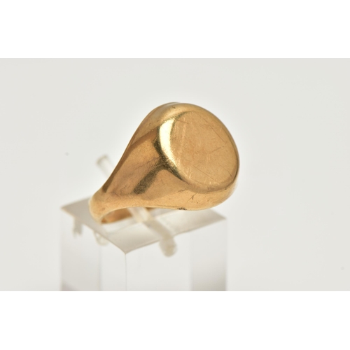 54 - A YELLOW METAL SIGNET RING, oval form signet with tapered shoulders, approximate width 16mm, stamped... 