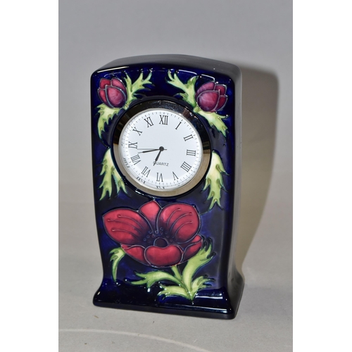 311 - A MOORCROFT POTTERY MANTEL CLOCK, decorated in the Anemone pattern on a dark blue ground, quartz mov... 