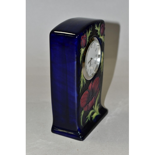 311 - A MOORCROFT POTTERY MANTEL CLOCK, decorated in the Anemone pattern on a dark blue ground, quartz mov... 