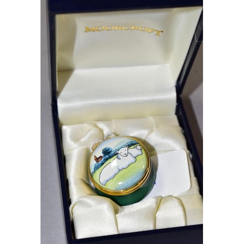 335 - A BOXED MOORCROFT ENAMELS PILL BOX, of circular form, decorated with sheep in a rural landscape, pri... 