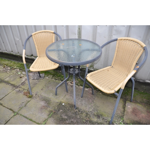 1005 - A CIRCULAR METAL GARDEN TABLE with glass top along with two rattan style chairs (3)