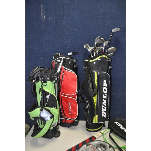 1083 - THREE JUNIOR GOLF BAGS containing various clubs such as Nike, Wilson, Dunlop, J-Tek and Masters and ... 