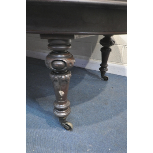 1223 - A VICTORIAN WALNUT WIND OUT DINING TABLE, with rounded ends, three additional leaves, on bulbous leg... 