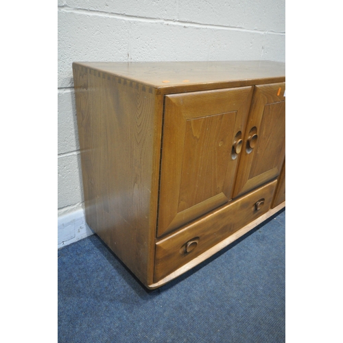 1257 - AN ERCOL BLONDE ELM SIDEBOARD, with double cupboard doors over a single drawer flanked by a single c... 