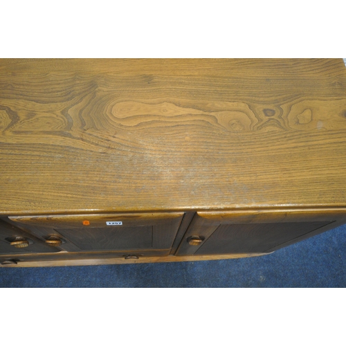 1257 - AN ERCOL BLONDE ELM SIDEBOARD, with double cupboard doors over a single drawer flanked by a single c... 