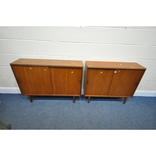 1299 - TWO SIMILAR MID-CENTURY AFROMOSIA TEAK SLIDING DOOR BOOKCASES, on tapering legs, largest width 107cm... 