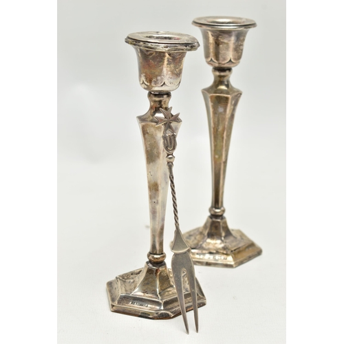 152 - A PAIR OF SILVER CANDLESTICKS AND A TWO PRONG FORK, the candlesticks of a tapered hexagonal form, on... 