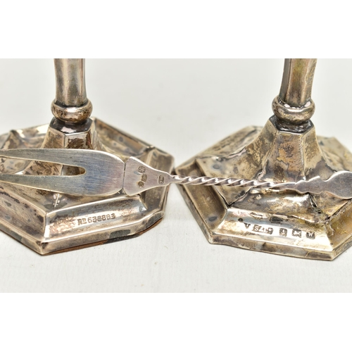 152 - A PAIR OF SILVER CANDLESTICKS AND A TWO PRONG FORK, the candlesticks of a tapered hexagonal form, on... 