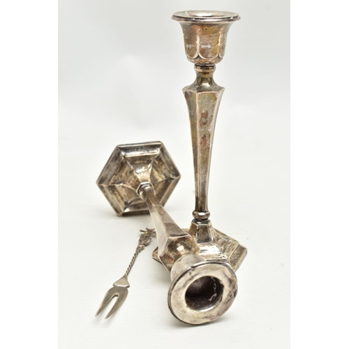 152 - A PAIR OF SILVER CANDLESTICKS AND A TWO PRONG FORK, the candlesticks of a tapered hexagonal form, on... 