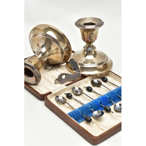 154 - AN ASSORTMENT OF SILVER, to include a pair of silver candle sticks on weighted bases, approximate he... 