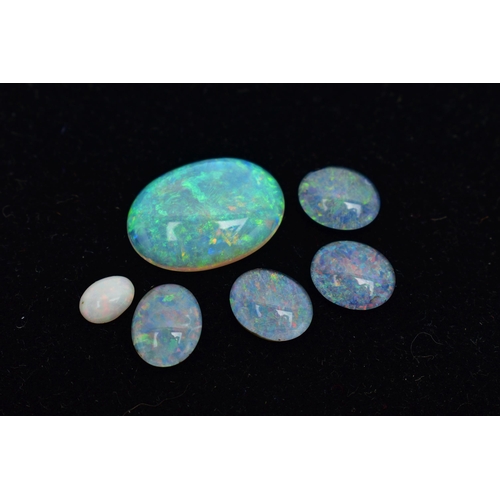 11 - FIVE LOOSE OPAL CABOCHON STONES, the first a large oval opal cabochon, showing flashes of blue, gree... 