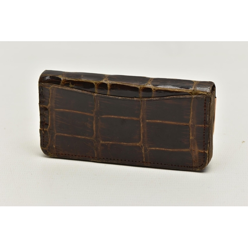 28 - AN EARLY 20TH CENTURY CROCODILE SKIN PURSE, mounted with two 9ct rose gold hard wear corners to the ... 